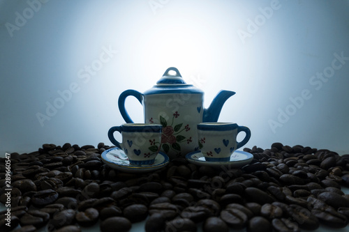 Modern coffee concept. Pot and coffee cup with coffee beans. Soft focus image and grain effect in a dark mode.