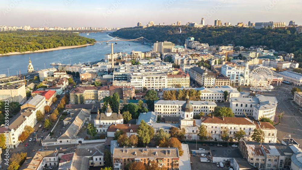 Aerial top view of Kyiv cityscape, Dnieper river and Podol historical district skyline from above, Kontraktova square with ferris wheel, city of Kiev, Ukraine