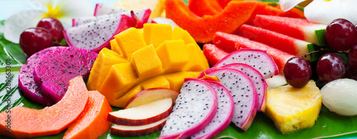 Tropical fruits assortment, palm leaf background. Close up.