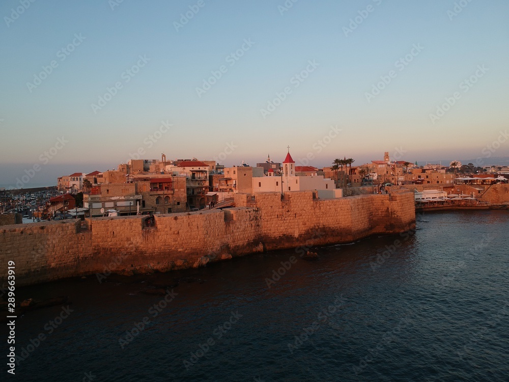 The old city of Acre and its walls in the red sunset 