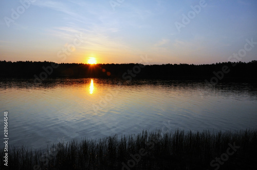 Sunset over the lake. The sky is in red rays.