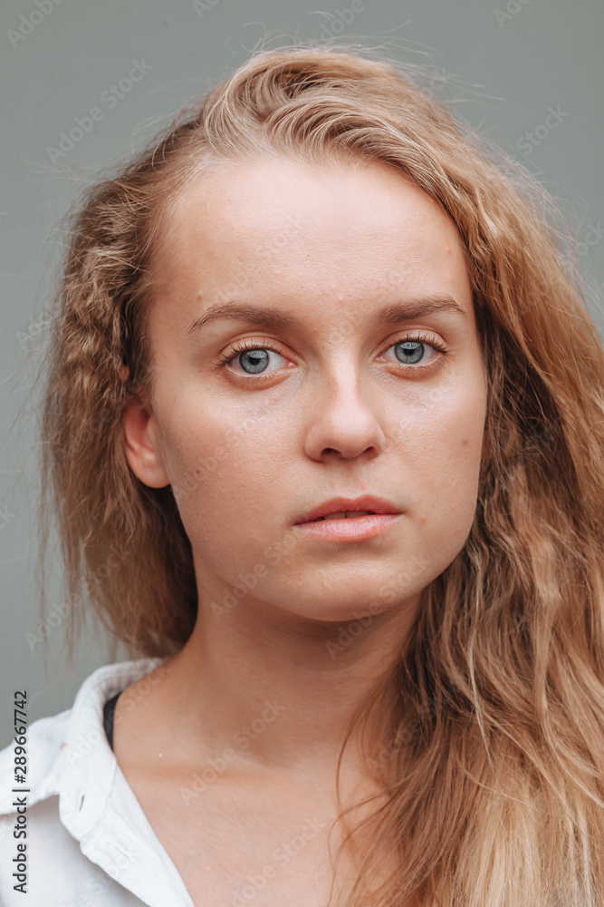 portrait close - up of a girl with blue eyes on a gray background