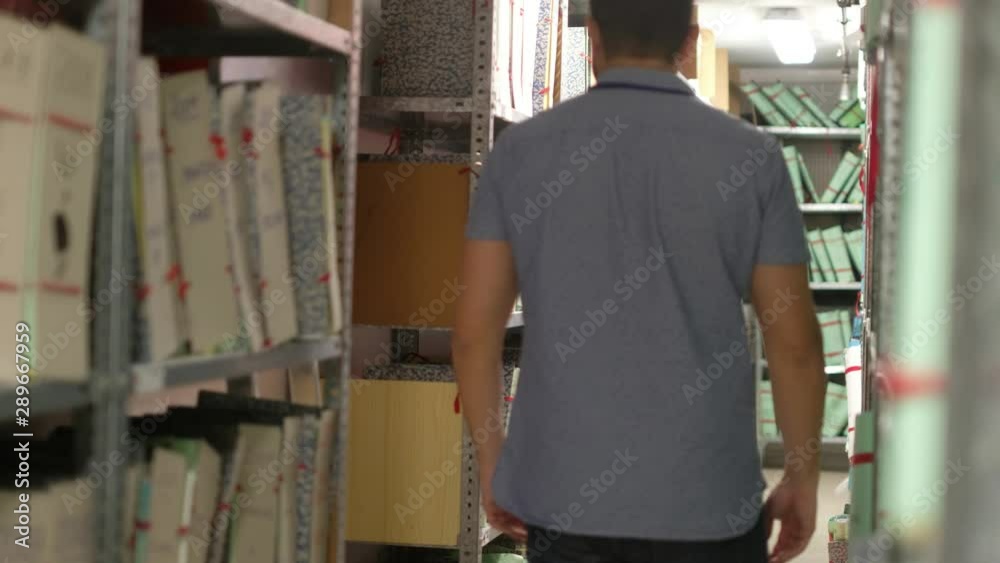 Man in files basement looking for search papers Man in files basement looking for search papers