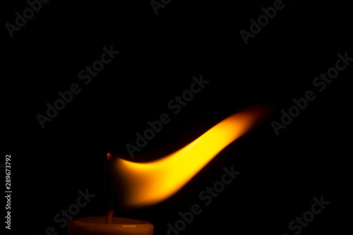 Freezed candle flame dance in black darkness