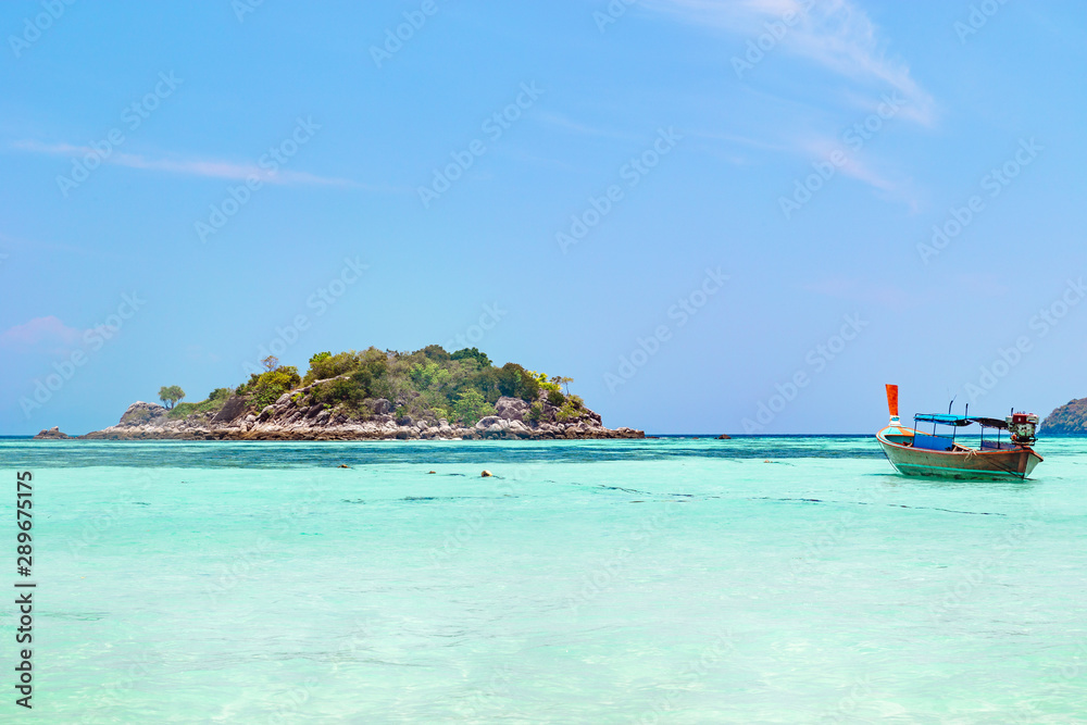 Tropical island with azure blue ocean and boat