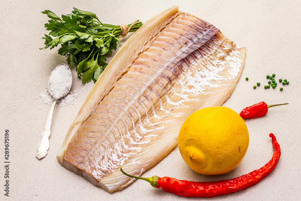 Raw cod loin fillet with lemon, sea salt, chili and cayenne pepper, parsley Raw cod loin fillet with lemon, sea salt, chili and cayenne pepper, parsley