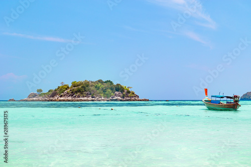 Tropical island with azure blue ocean and boat