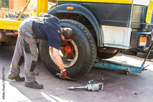 tire repairer at work that changes and repairs truck and car tires in the garage
