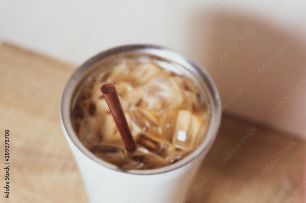 a bottle of iced coffee and brown plastic straw on wood surface table a bottle of iced coffee and brown plastic straw on wood surface table