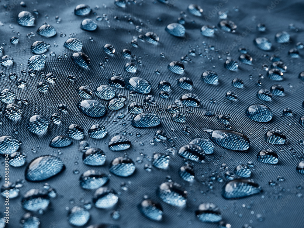 Rain water droplets on blue fiber waterproof fabric. Blue background. Rain water droplets on blue fiber waterproof fabric. Blue background.