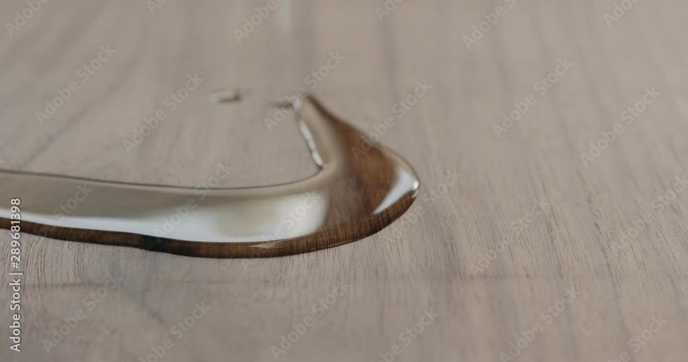 Slow motion pour oil onto black walnut board Slow motion pour oil onto black walnut board