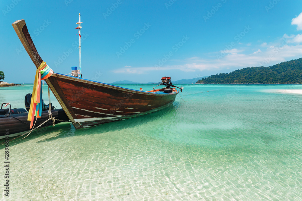 Traditional wooden Thai boat in sunlit water