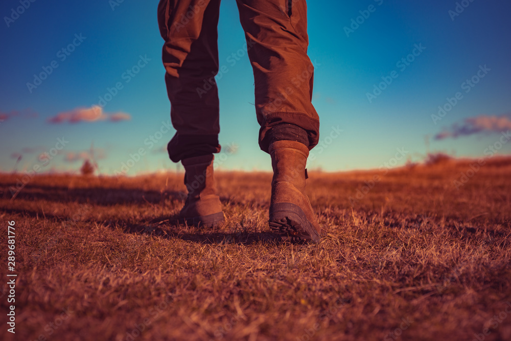 hiking and camping. travel adventure. future. military shoes. male feet in green boots. hynter searching for victim in grass field. going to success. freedom. soldier uniform. step up. walking. legs hiking and camping. travel adventure. future. military shoes. male feet in green boots. hynter searching for victim in grass field. going to success. freedom. soldier uniform. step up. walking. legs