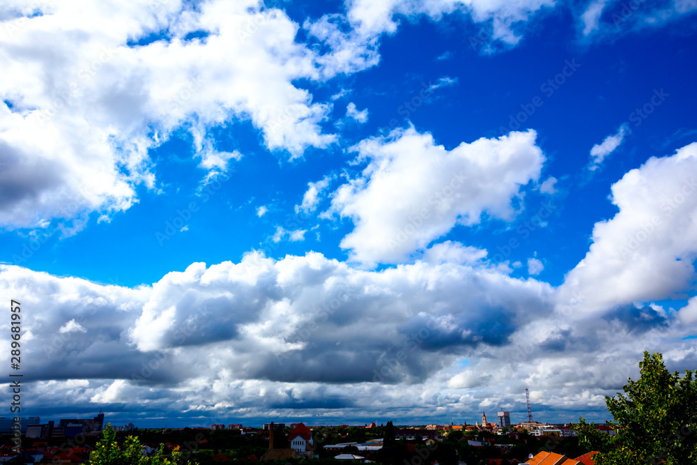 Blue sky with white clouds, town in the distance