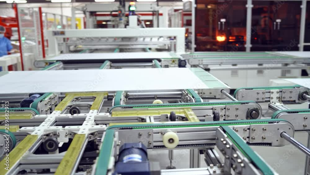 Modern automated solar energy production. Factory producing solar panels. Industrial robotic machinery working on a solar panel plant. Modern automated solar energy production. Factory producing solar panels. Industrial robotic machinery working on a solar panel plant.