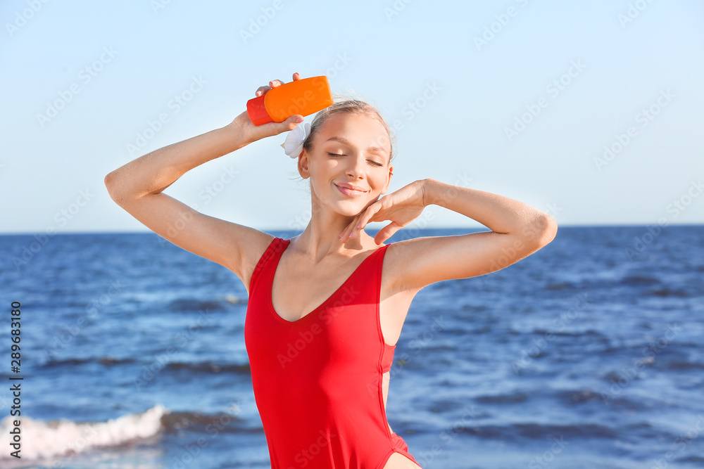 Beautiful young woman with sun protection cream on sea beach Beautiful young woman with sun protection cream on sea beach