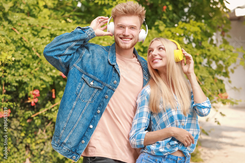 Young couple listening to music outdoors