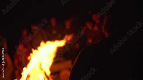 Silhouettes of people sitting around campfire