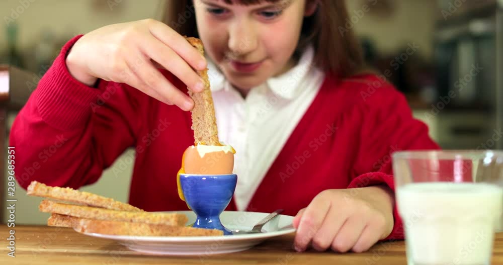 Girl Wearing School Uniform Eating Healthy Boiled Egg For Breakfast In Kitchen