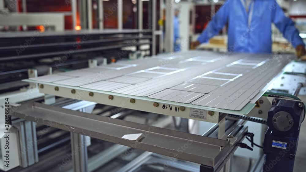 Producing process of solar panel. Automated technology of producing solar cells. Ready solar panel on the board on a modern factory background.
