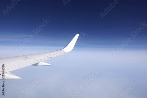 Passenger supersonic plane wing view from the moving airplane high in the sky