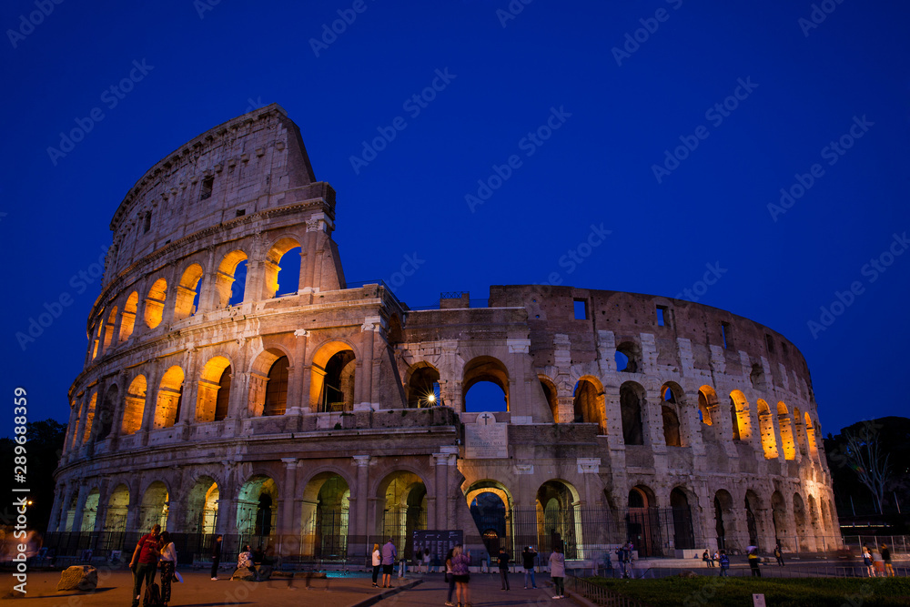 Tourists visiting the famous Colosseum at night in Rome