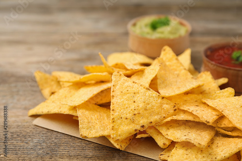 Mexican nacho chips on wooden table, closeup