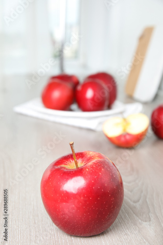 Ripe juicy red apples on white wooden table indoors
