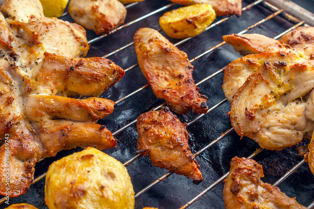 Roasted Potatoes and Chicken Slices on Stainless Steel Cooking Grid. Grilled Chicken Breast with Slices Made for Marinade to Penetrate the Meat Better, and Ensure Chicken Cooked Evenly. Roasted Potatoes and Chicken Slices on Stainless Steel Cooking Grid. Grilled Chicken Breast with Slices Made for Marinade to Penetrate the Meat Better, and Ensure Chicken Cooked Evenly.