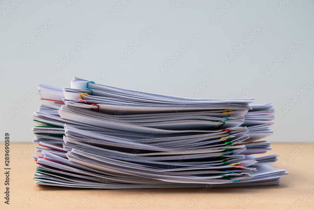Stack of document paper with colorful paperclip place on wooden table. Stack of document paper with colorful paperclip place on wooden table.