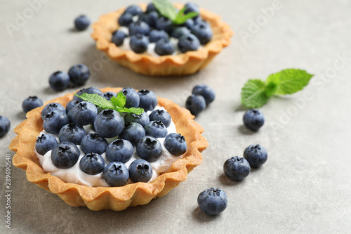 Delicious sweet pastry with berries on grey table. Space for text