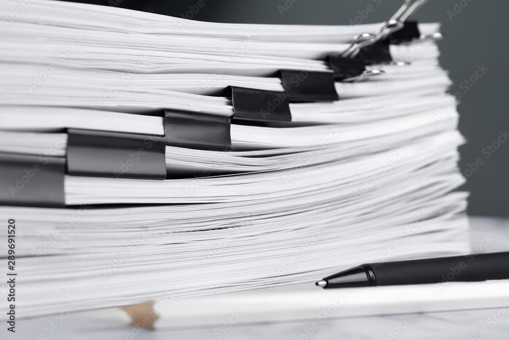 Stack of documents with binder clips on marble table, closeup Stack of documents with binder clips on marble table, closeup