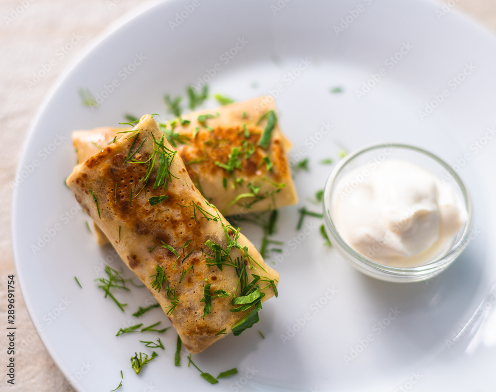 Homemade pancakes with filling and sour cream Homemade pancakes with filling and sour cream