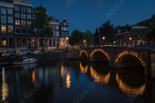 Lights of the city reflected on the canal at night, Amsterdam, the Netherlands