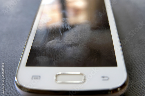 Fingerprint marks and smudges on a dirty, unclean smartphone touchscreen where build up over time can interfere or decrease touch sensitivity of the screen.