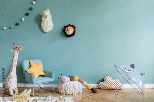 Stylish scandinavian kid room with toys, teddy bear, plush animal toys, mint armchair, umbrella, cotton balls. Modern interior with eucalyptus background walls, Design interior of childroom. Template  photo