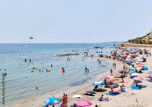 Fototapeta Naklejka Na Ścianę i Meble -  People enjoy summer holidays on the sandy beach Campoamor, Province Alicante, Spain