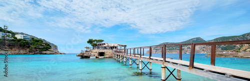 Wooden walkway leading across turquoise Mediterranean Sea panoramic image