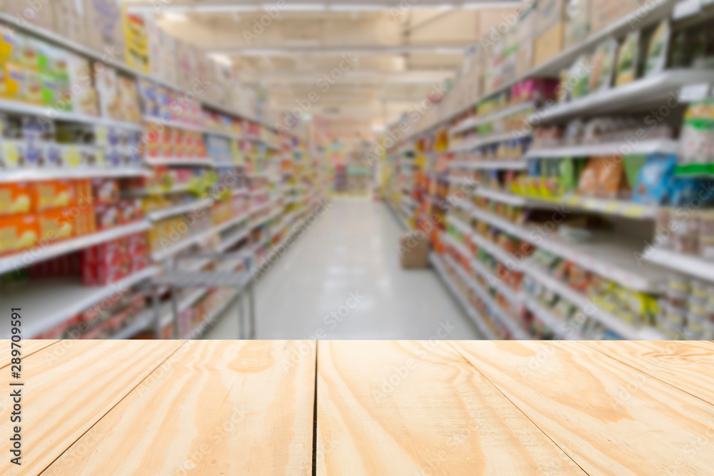 Wood table top on blur supermarket shelf background