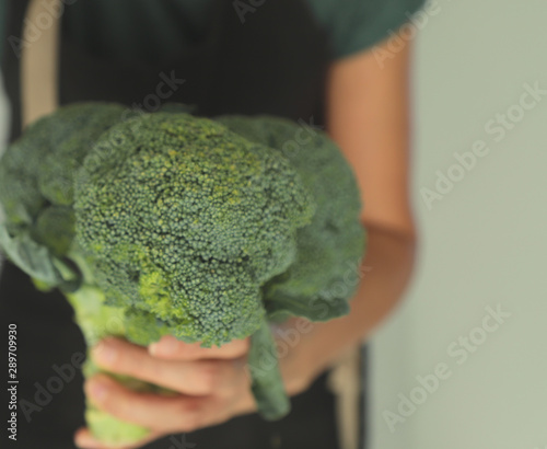 Closeup female hand holds a with beautiful appetizing broccoli