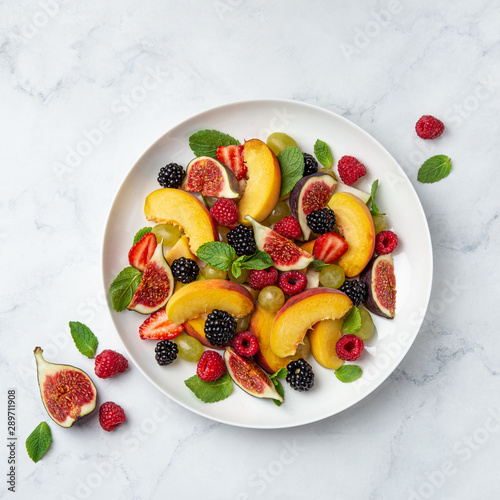 Sweet fruit and berry salad on white plate