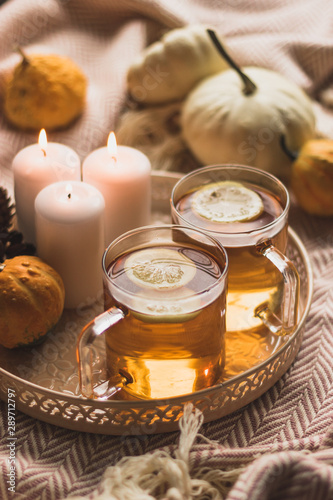 autumn cosy pumpkin, candles and autumn plants on window with led lights bokeh