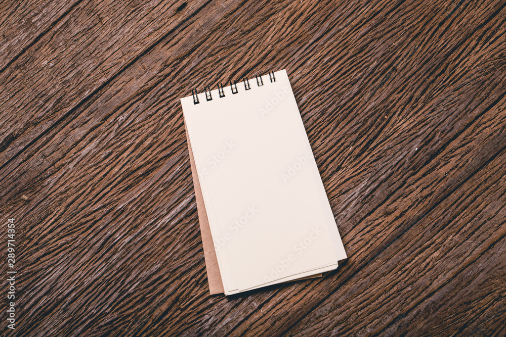 Blank notepad for your message on grunge wooden table Blank notepad for your message on grunge wooden table