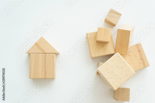 miniature small house made wooden blocks background of a stack of cubes for assembly.