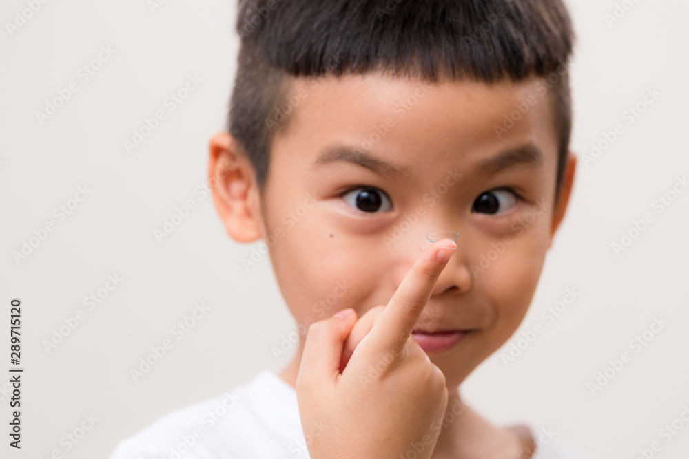 Asian little boy look at the contact lens Asian little boy look at the contact lens