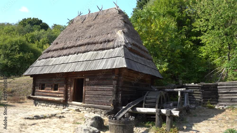 Kiev, Ukraine, Europe - September 2019: Old water mill among the forest. Old wooden house with thatched roof. Pirogovo Museum. Kiev, Ukraine, Europe - September 2019: Old water mill among the forest. Old wooden house with thatched roof. Pirogovo Museum.