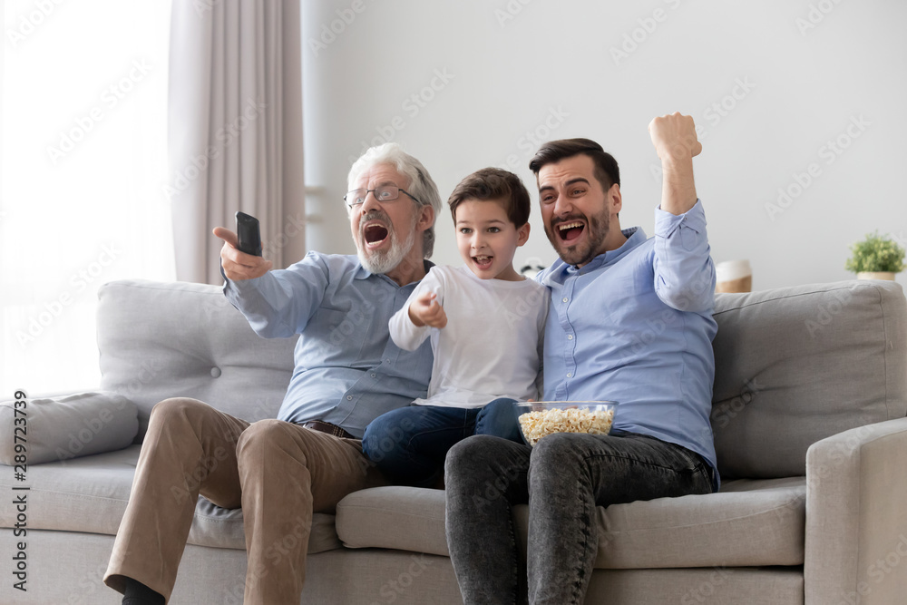 Excited three generation men family watch tv sport game