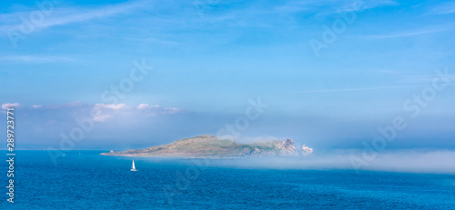 Low lying mist covering Irelands Eye island, view from Howth, Ireland