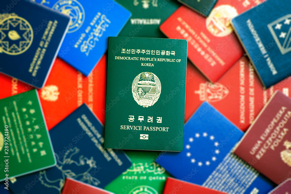 North Korea biometric green service passport on blurry colorful background of passports of