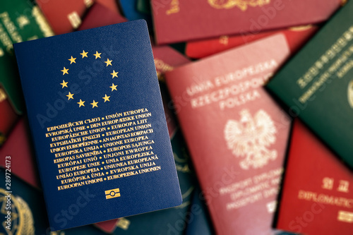 European Union blue biometric passport on blurry colorful background of passports of different countries of the world.